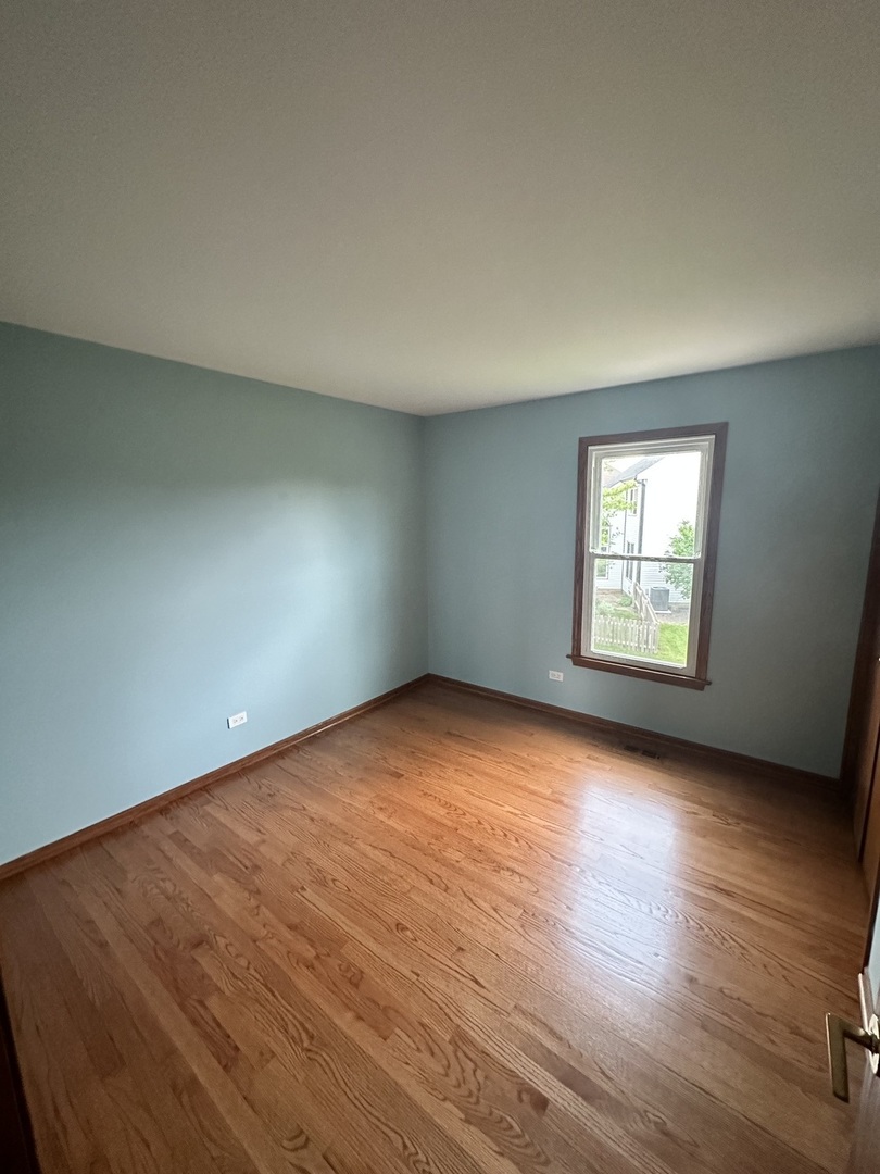 1592 Wakefield Court Mundelein, IL 60060 - Photo 17 of 25 an empty room with wooden floor and windows
