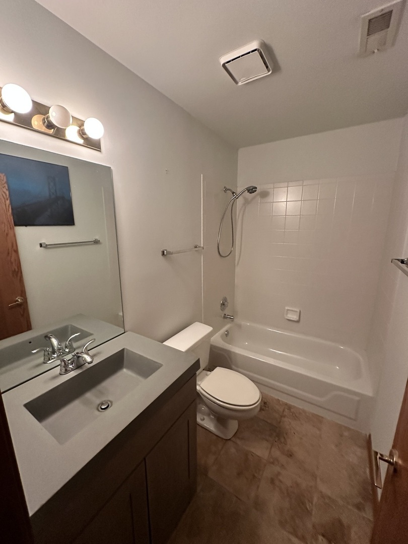 1592 Wakefield Court Mundelein, IL 60060 - Photo 21 of 25 a bathroom with a sink a toilet a mirror and shower