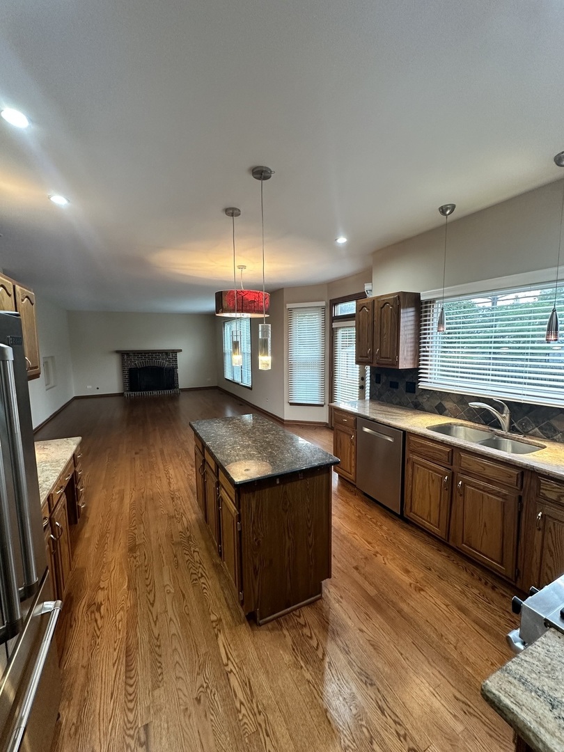 1592 Wakefield Court Mundelein, IL 60060 - Photo 8 of 25 a kitchen with stainless steel appliances granite countertop a stove and a wooden floors