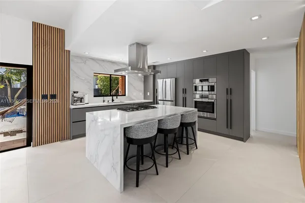 a kitchen with stainless steel appliances kitchen island granite countertop a sink and cabinets