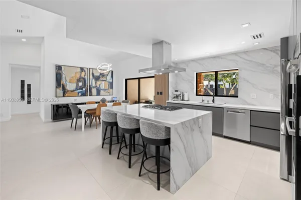 a kitchen with a table chairs sink and cabinets