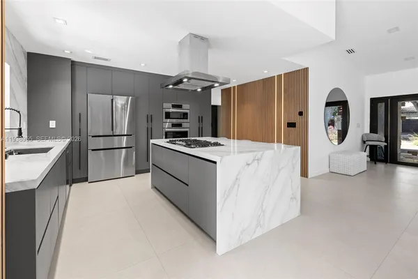 a kitchen with stainless steel appliances kitchen island a refrigerator sink and stove