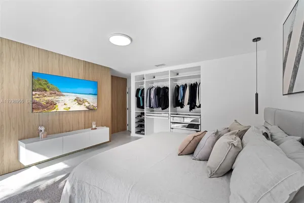 a bedroom with a large bed and a flat screen tv