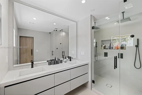a bathroom with a shower sink and mirror
