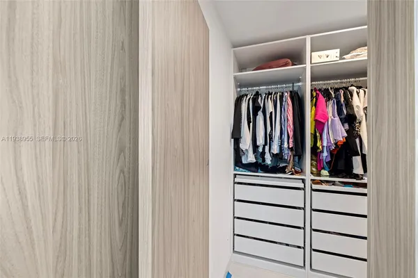 a view of walk in closet with clothes