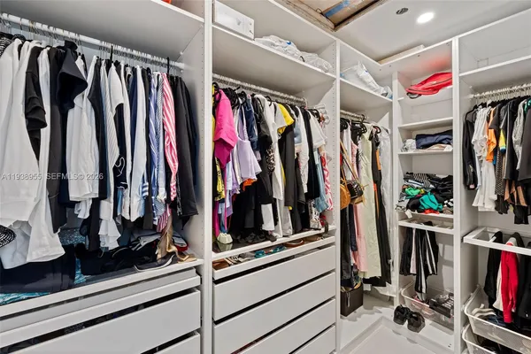 a view of walk in closet with clothes
