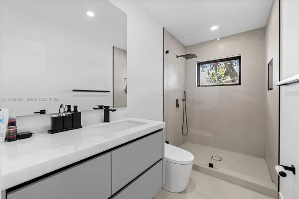 a bathroom with a double vanity sink toilet and shower