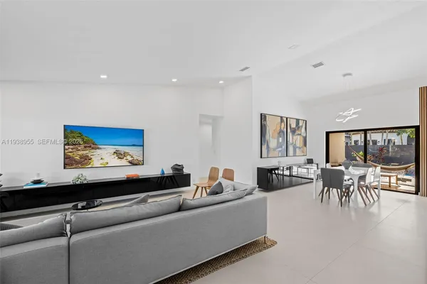 a living room with furniture two window and a flat screen tv
