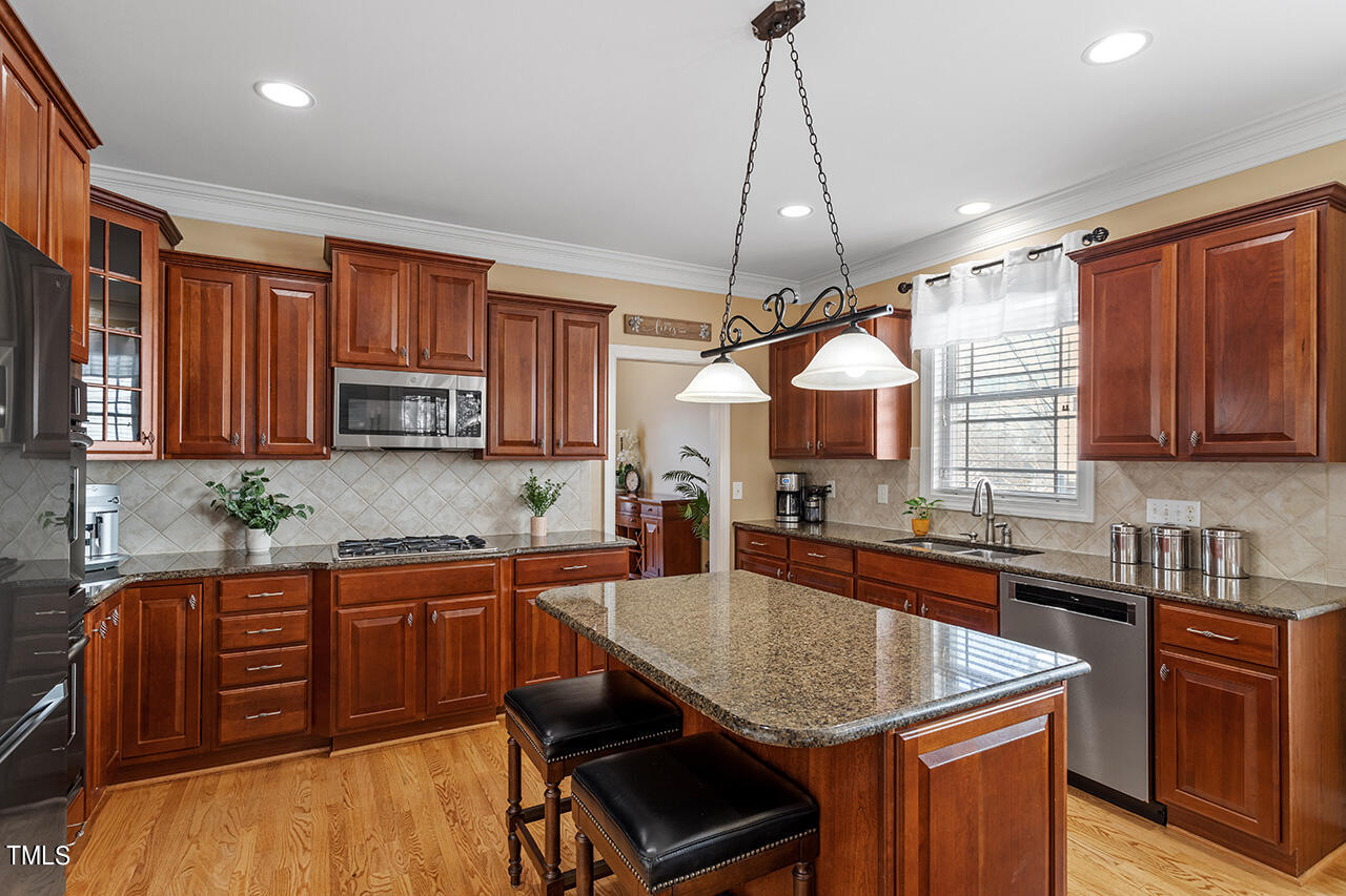 102 Juliet Circle Cary, NC 27513 - Photo 15 of 42 a kitchen with stainless steel appliances granite countertop a sink a stove counter space and cabinets