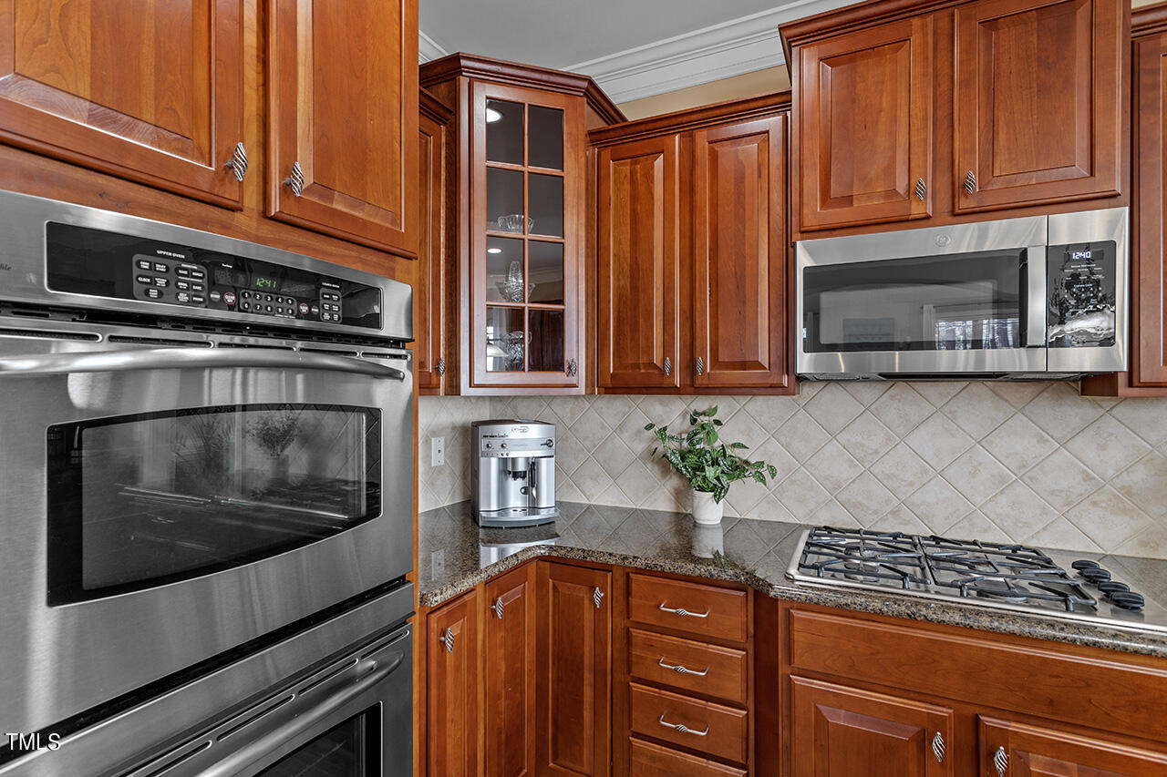 102 Juliet Circle Cary, NC 27513 - Photo 18 of 42 a kitchen with stainless steel appliances granite countertop a stove a microwave and cabinets