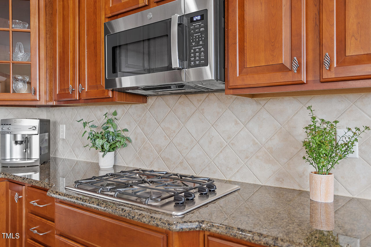 102 Juliet Circle Cary, NC 27513 - Photo 19 of 42 a kitchen with stainless steel appliances granite countertop a sink a stove a microwave and cabinets