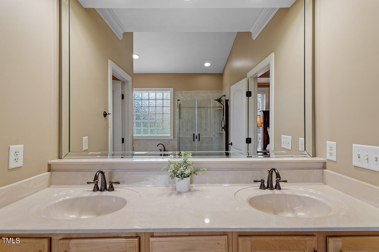 102 Juliet Circle Cary, NC 27513 - Photo 26 of 42 a bathroom with double vanity sinks a mirror and a bathtub