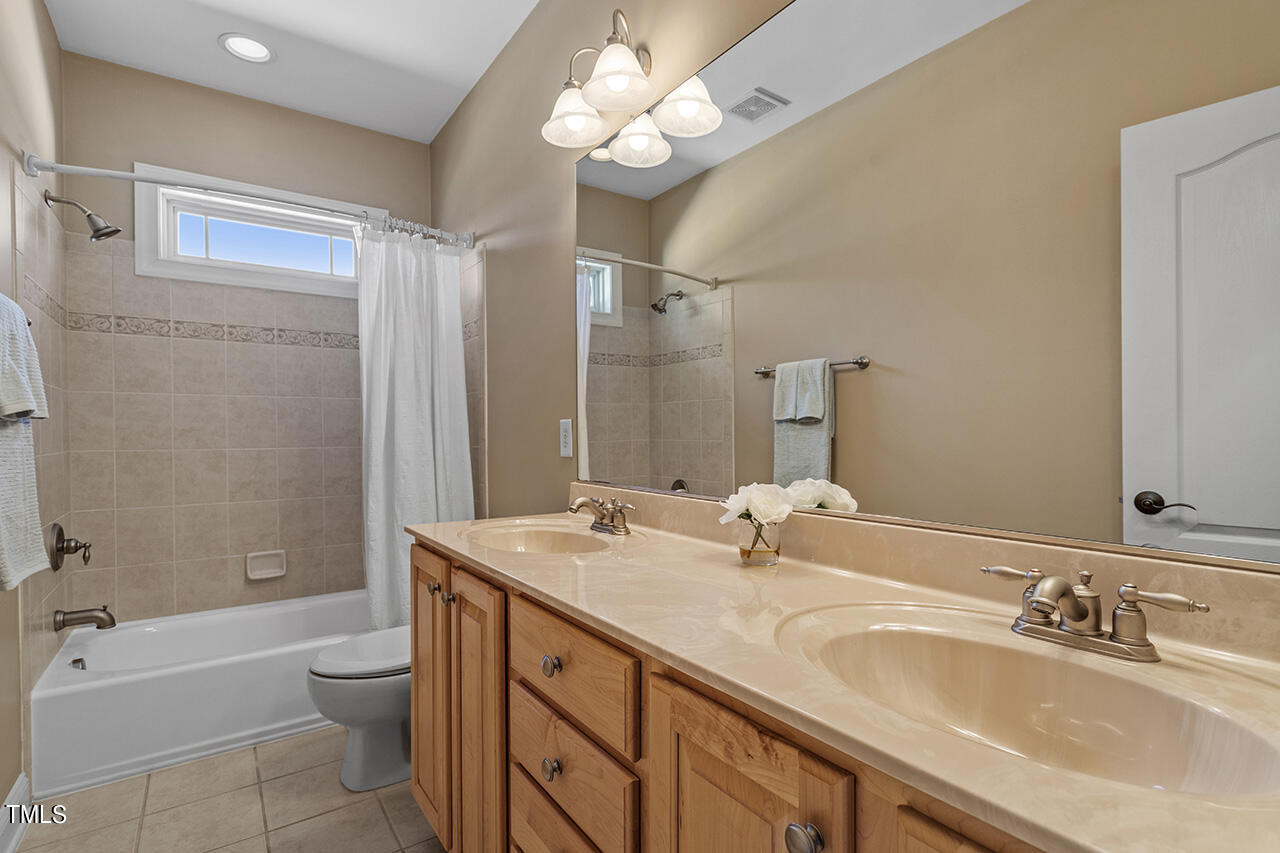 102 Juliet Circle Cary, NC 27513 - Photo 32 of 42 a bathroom with a double vanity sink double mirror bathtub shower and toilet