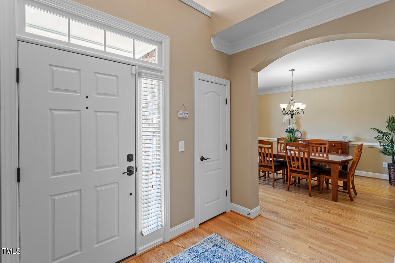 102 Juliet Circle Cary, NC 27513 - Photo 5 of 42 a dining room with furniture wooden floor a rug and a chandelier