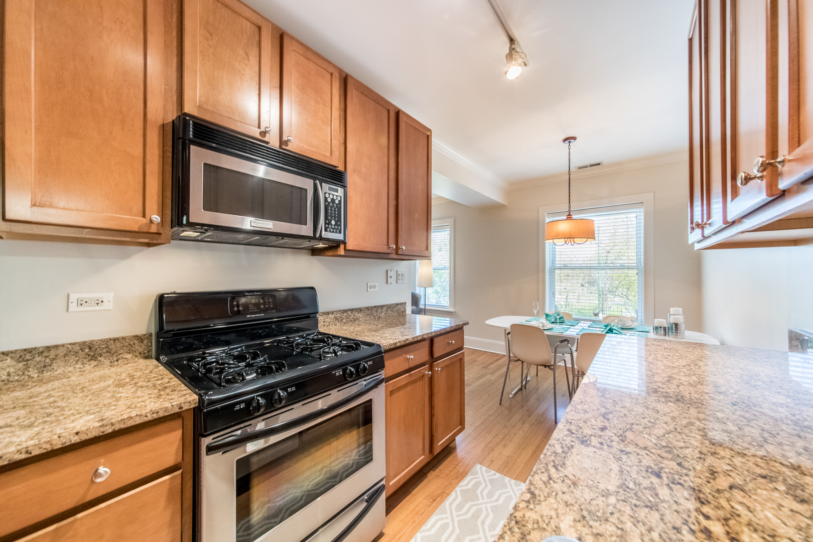 4306 North Clark Street, Unit 2 Chicago, IL 60613 - Photo 11 of 25 a kitchen with stainless steel appliances granite countertop a stove a sink and a microwave