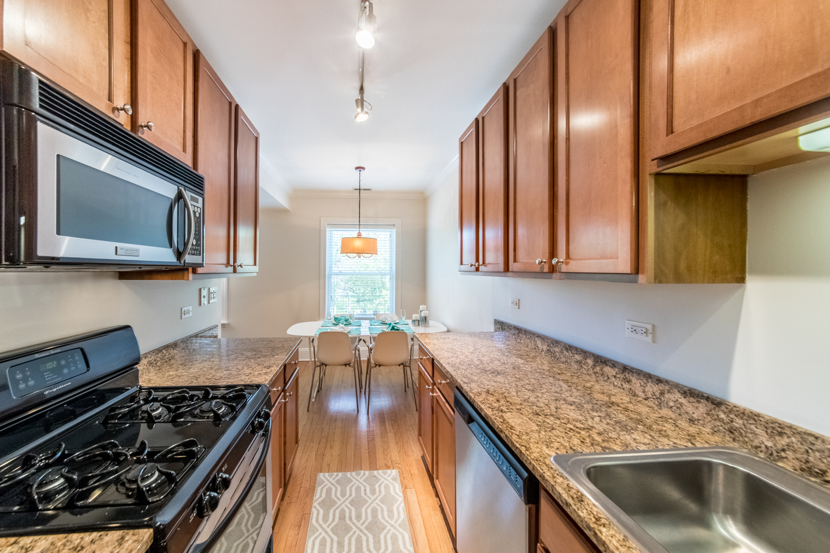 4306 North Clark Street, Unit 2 Chicago, IL 60613 - Photo 12 of 25 a kitchen with stainless steel appliances granite countertop a sink stove and cabinets