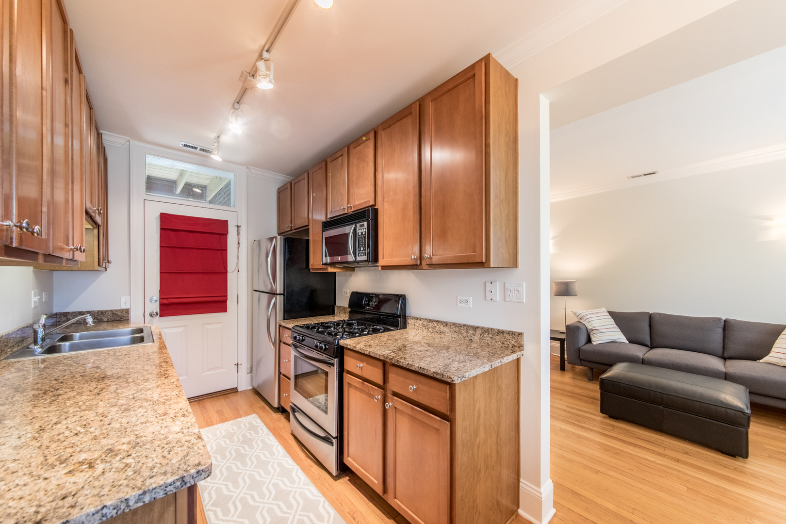 4306 North Clark Street, Unit 2 Chicago, IL 60613 - Photo 8 of 25 a kitchen with stainless steel appliances granite countertop a stove a sink and a refrigerator