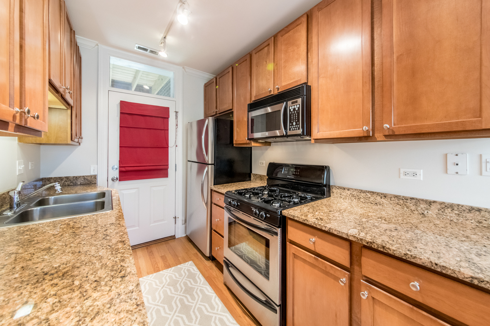 4306 North Clark Street, Unit 2 Chicago, IL 60613 - Photo 10 of 25 a kitchen with stainless steel appliances granite countertop a stove a sink and a microwave