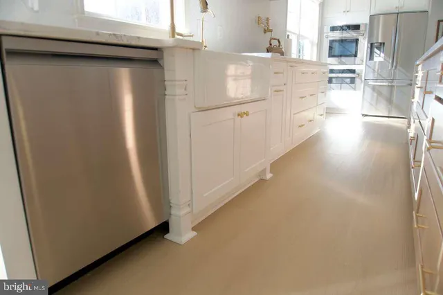 a kitchen with white cabinets and white appliances