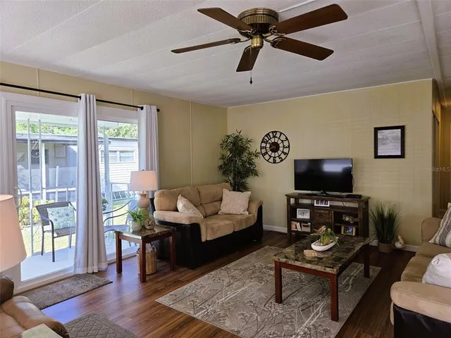 a living room with furniture ceiling fan and a window
