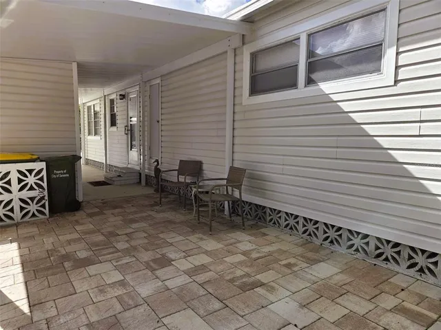 a backyard of a house with chairs and table