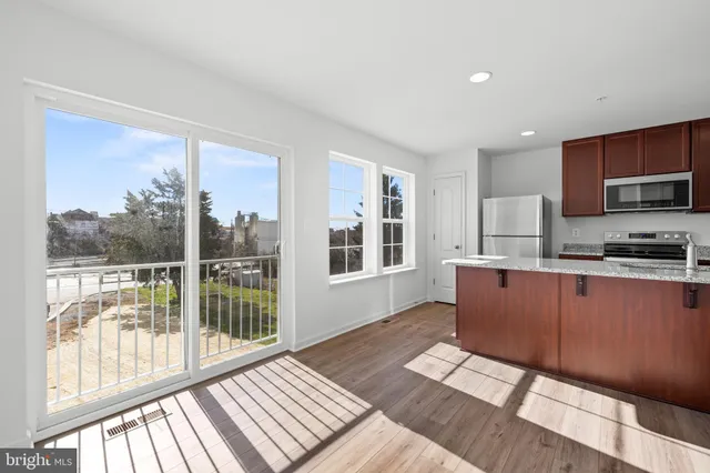 a kitchen with stainless steel appliances granite countertop a stove a sink and a granite counter tops with wooden floors