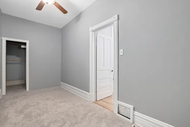 an empty room with chandelier fan