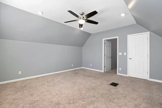 an empty room with closet and ceiling fan