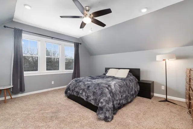 a spacious bedroom with a bed and a large window