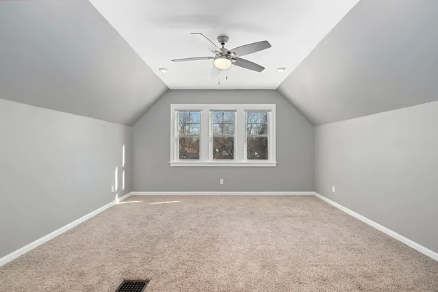 an empty room with window and ceiling fan