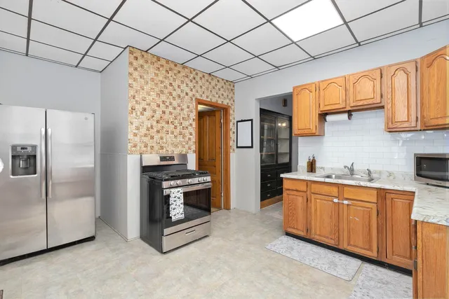 a kitchen with stainless steel appliances granite countertop a refrigerator a stove and a sink