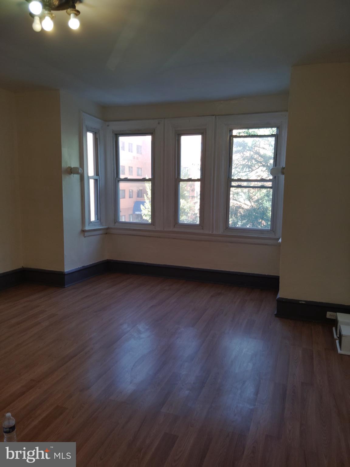 4514 Walnut Street Philadelphia, PA 19139 - Photo 8 of 10 an empty room with wooden floor and windows