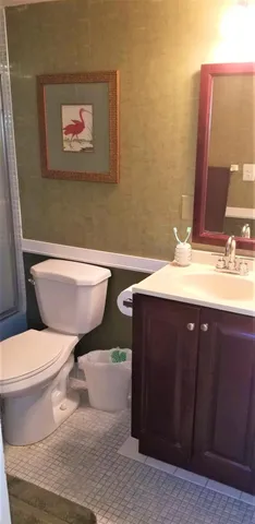 a bathroom with a toilet a sink and mirror