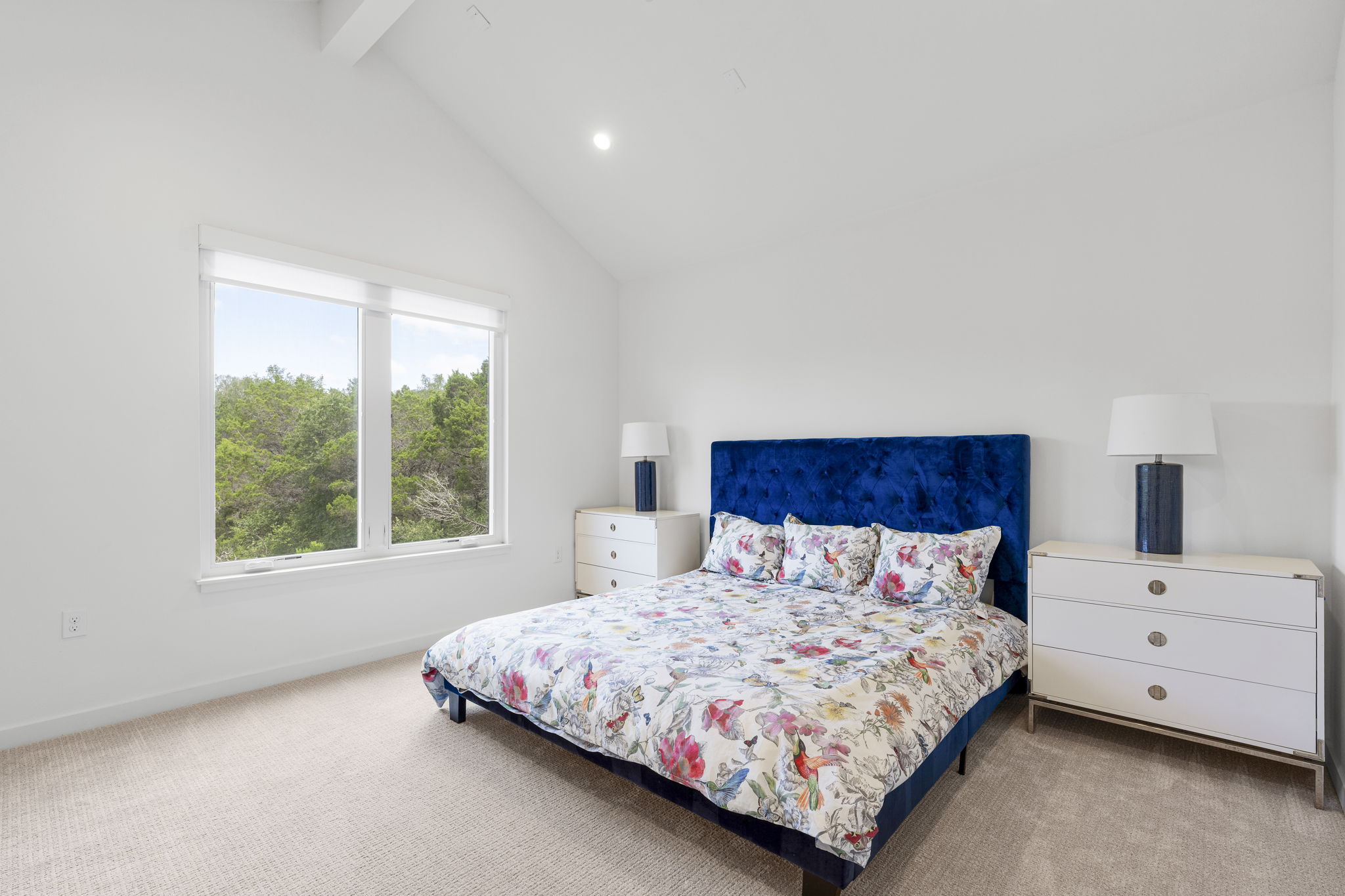 2520 Sutherland Street Austin, TX 78746 - Photo 16 of 26 A restful primary bedroom retreat with vaulted ceilings and a private greenbelt outdoor view.