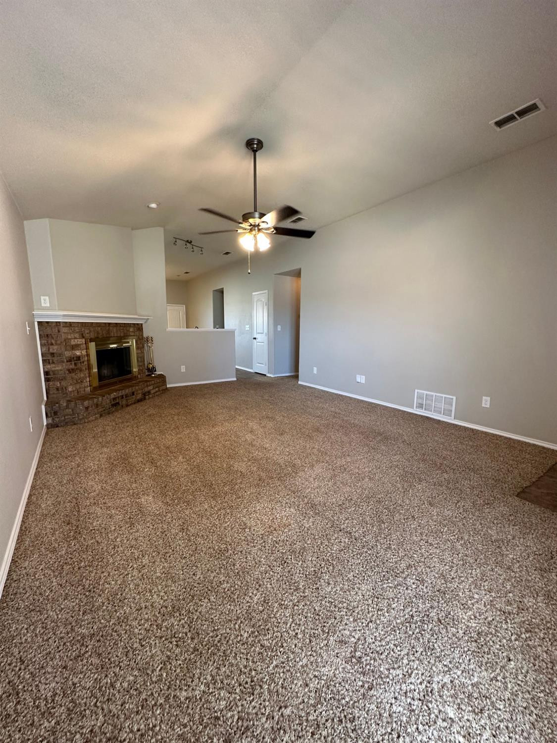 9316 Rochester Avenue Lubbock, TX 79424 - Photo 2 of 15 an empty room with kitchen view and a chandelier
