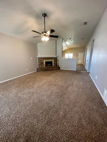 a view of an empty room with a fireplace and fan