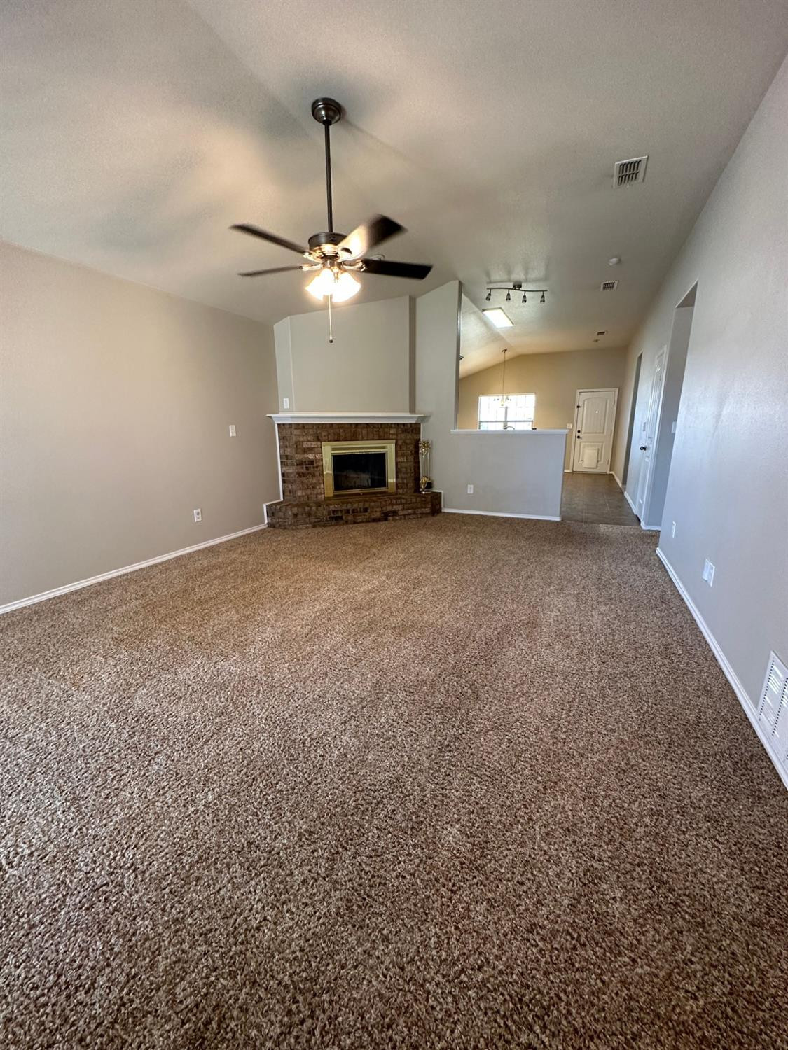 9316 Rochester Avenue Lubbock, TX 79424 - Photo 3 of 15 a view of an empty room with a fireplace and fan