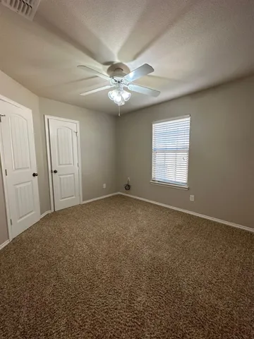 an empty room with windows and fan