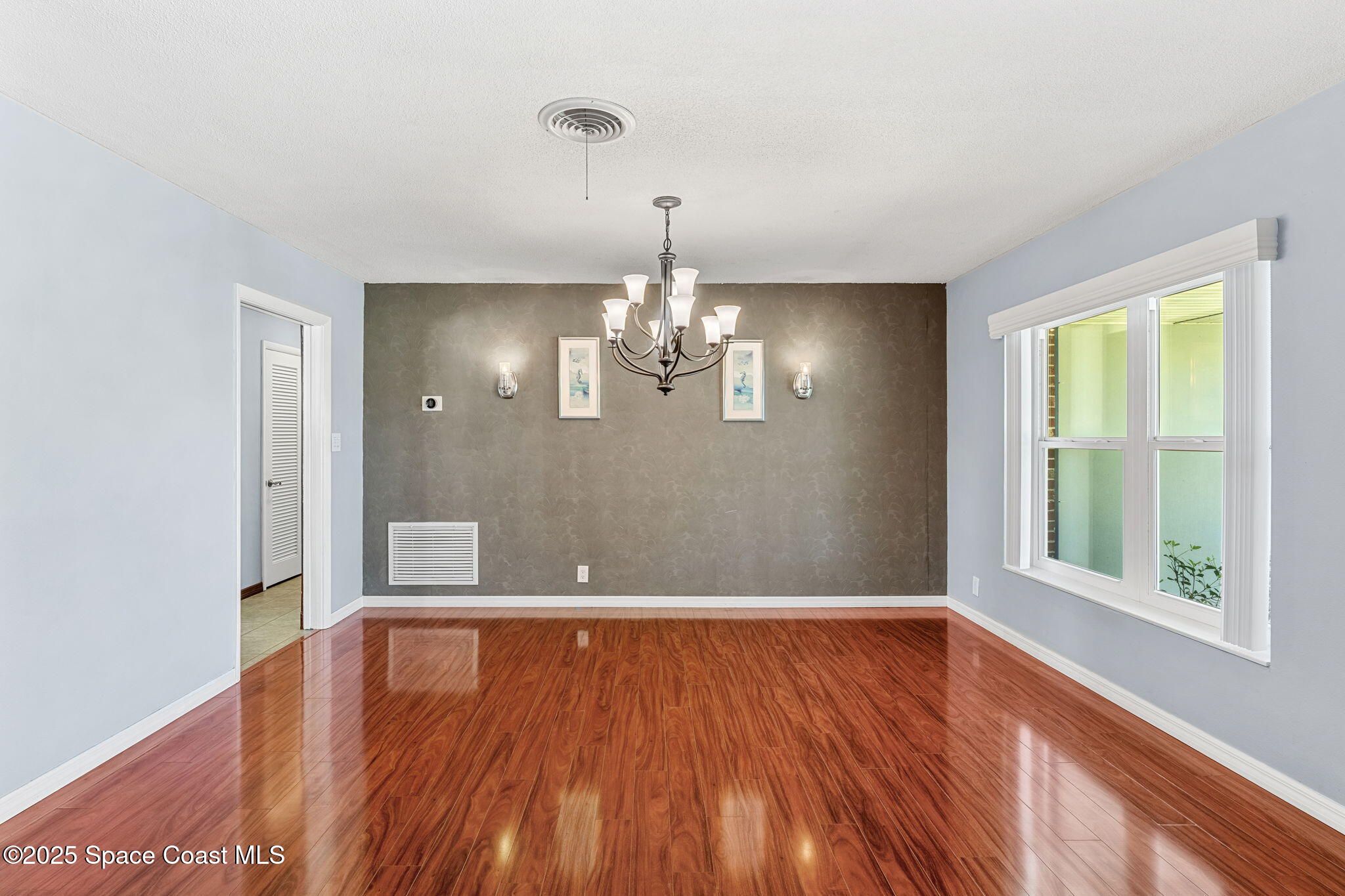 157 Cocoa Avenue Indialantic, FL 32903 - Photo 4 of 36 a view of an empty room with window and wooden floor