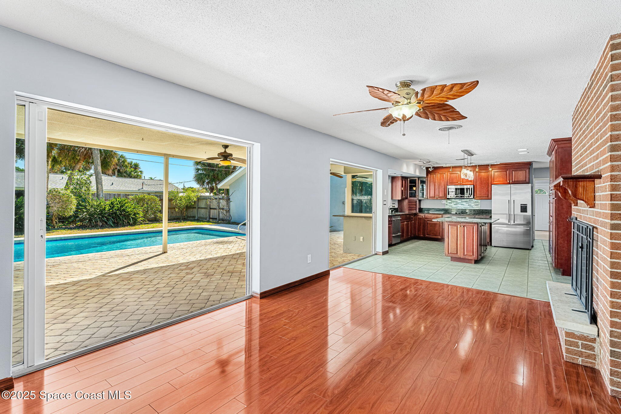 157 Cocoa Avenue Indialantic, FL 32903 - Photo 7 of 36 a view of a livingroom with a fireplace a ceiling fan and wooden floor