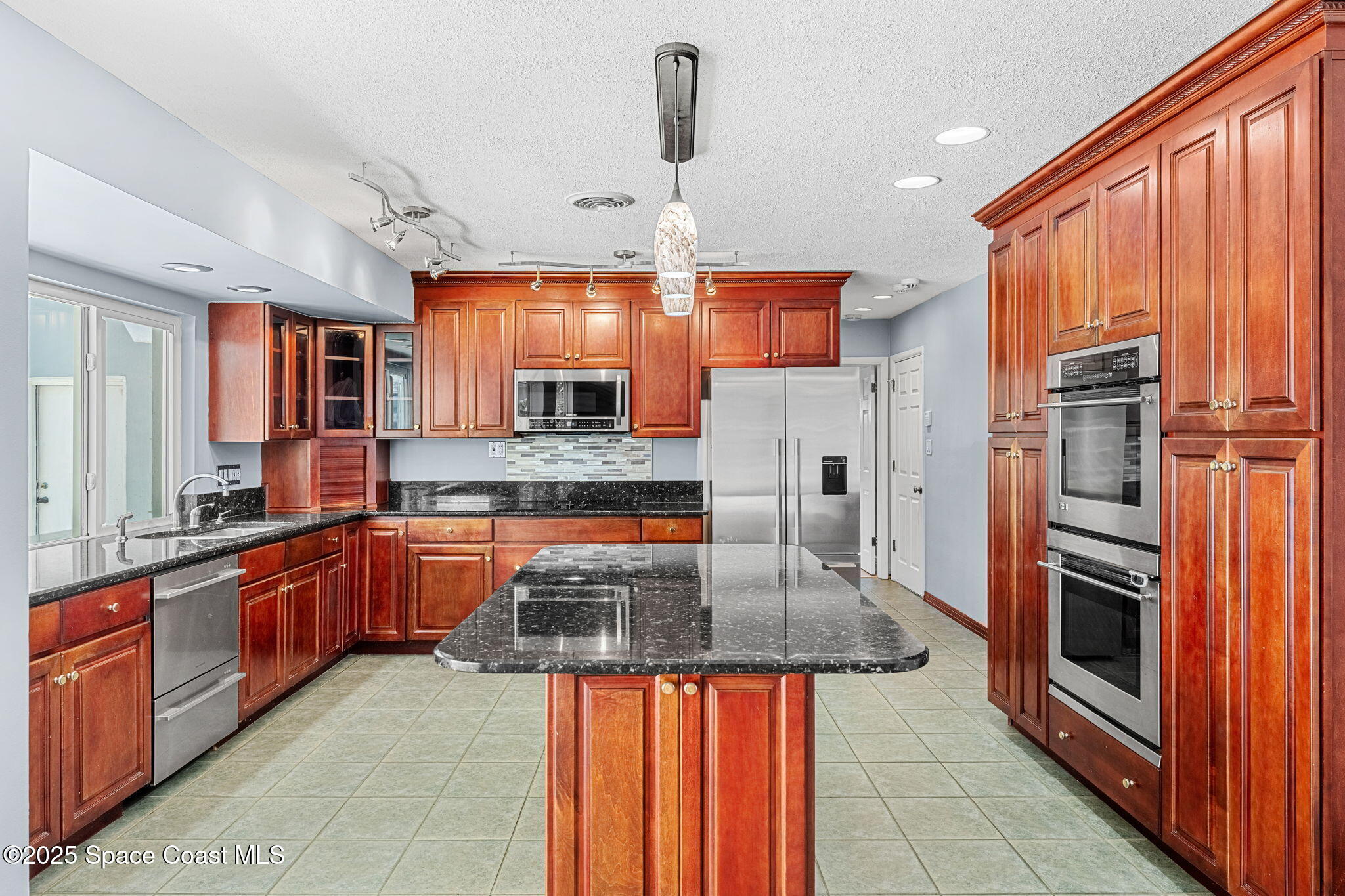157 Cocoa Avenue Indialantic, FL 32903 - Photo 9 of 36 a kitchen with stainless steel appliances granite countertop a sink a stove and cabinets