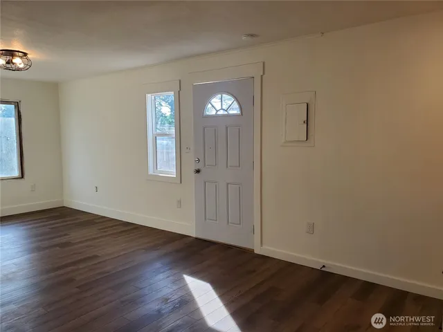 an empty room with wooden floor and window