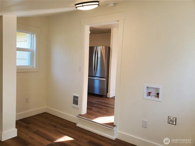 a view of empty room with wooden floor