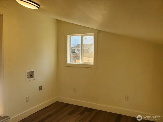 a view of a small space with wooden floor and a window