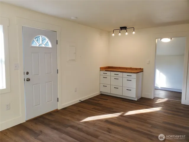 an empty room with wooden floor and window