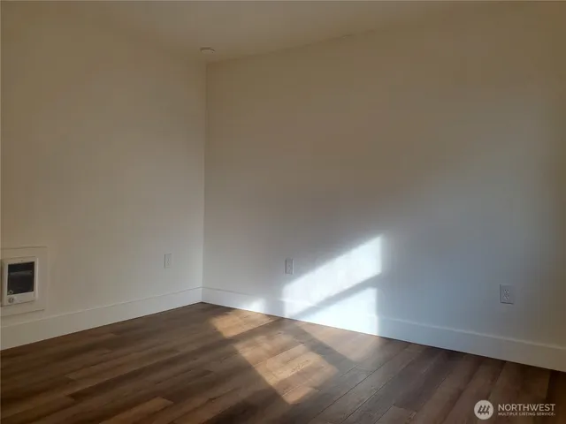 a view of an empty room and wooden floor