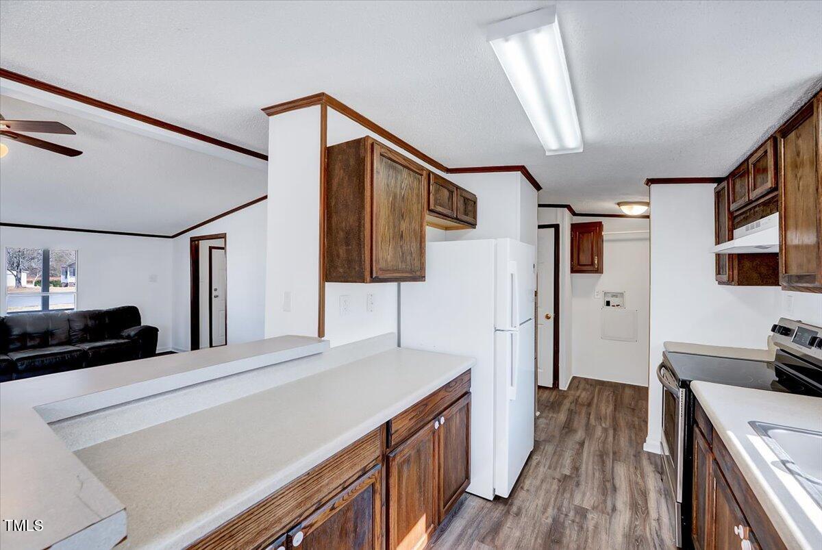 56 Jefferson Lane Cameron, NC 28326 - Photo 19 of 38 a kitchen with stainless steel appliances a stove a refrigerator a sink dishwasher and wooden cabinets with wooden floor