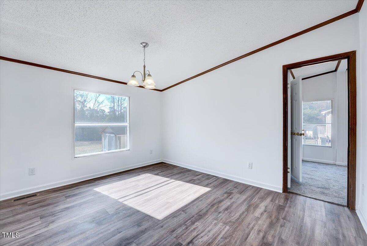 56 Jefferson Lane Cameron, NC 28326 - Photo 7 of 38 an empty room with wooden floor chandelier and windows