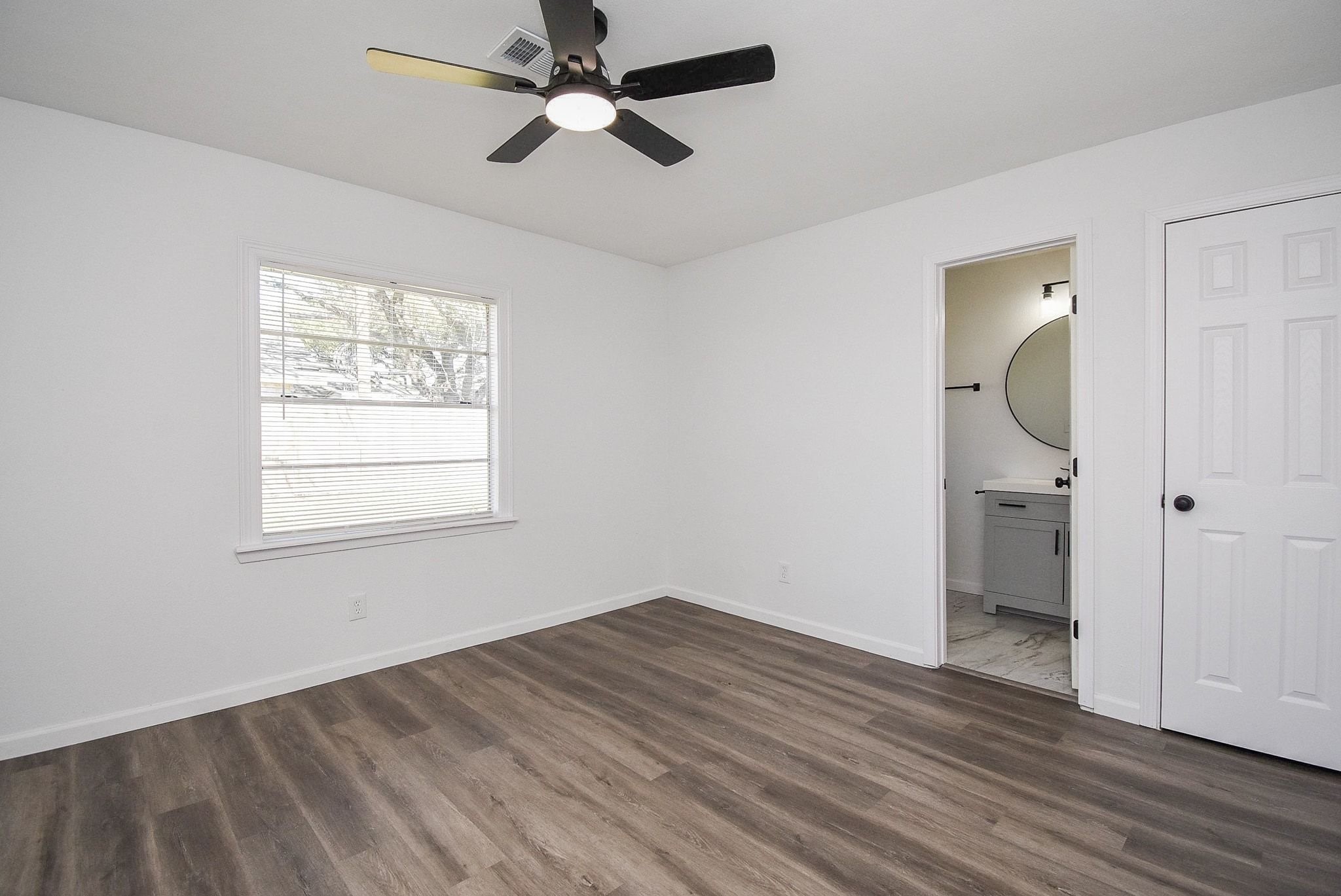 514 Peach Spring Drive Houston, TX 77037 - Photo 15 of 27 a view of empty room with wooden floor and fan