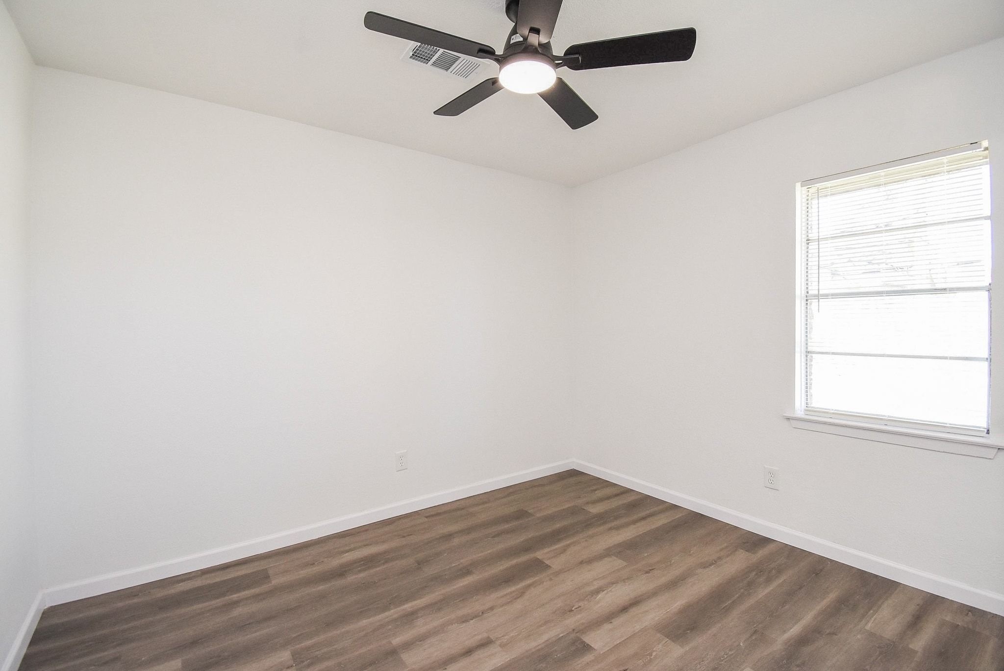 514 Peach Spring Drive Houston, TX 77037 - Photo 21 of 27 an empty room with a window and a ceiling fan